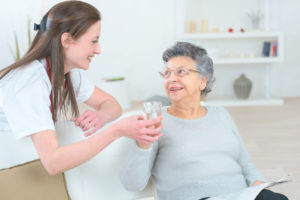 Caregiver-Giving-Water-to-Elderly-Woman-300x200